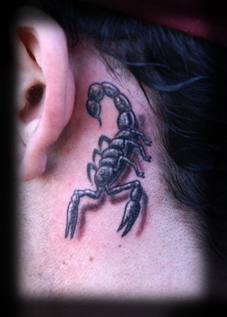 On her back she has a scorpion tattoo & a Chinese Tattoo on the back of her