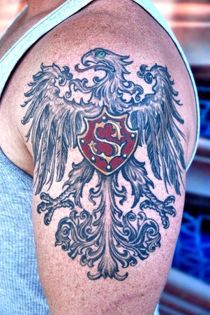 Comments: Family crest tattoo, black and gray arm piece with hint of color.